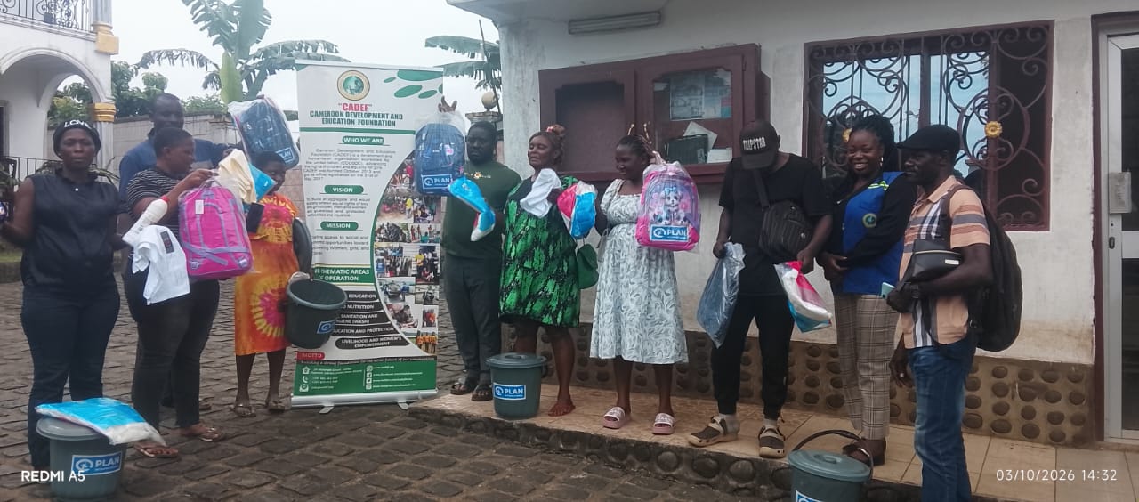 Community members and CADEF personnel outside the office holding Plan-branded school bags and relief supplies